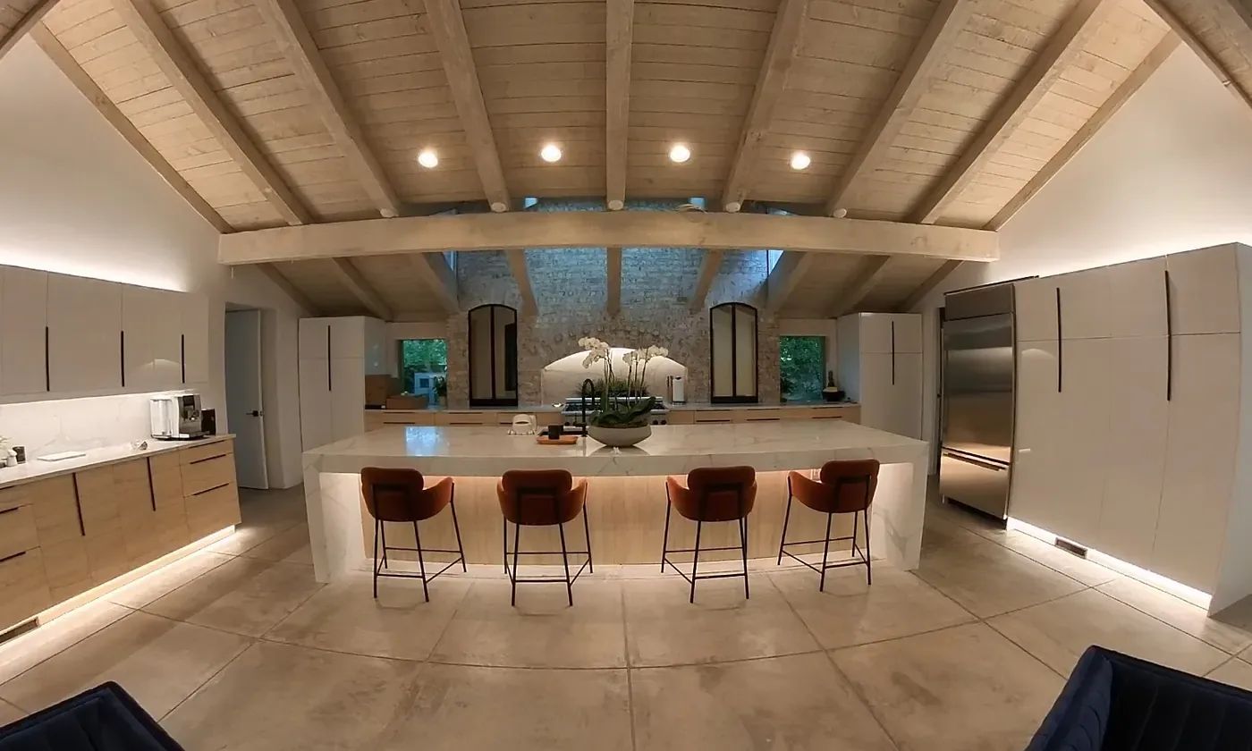 Open-plan kitchen and living room with warm-dim lighting, a WH Technologies installation