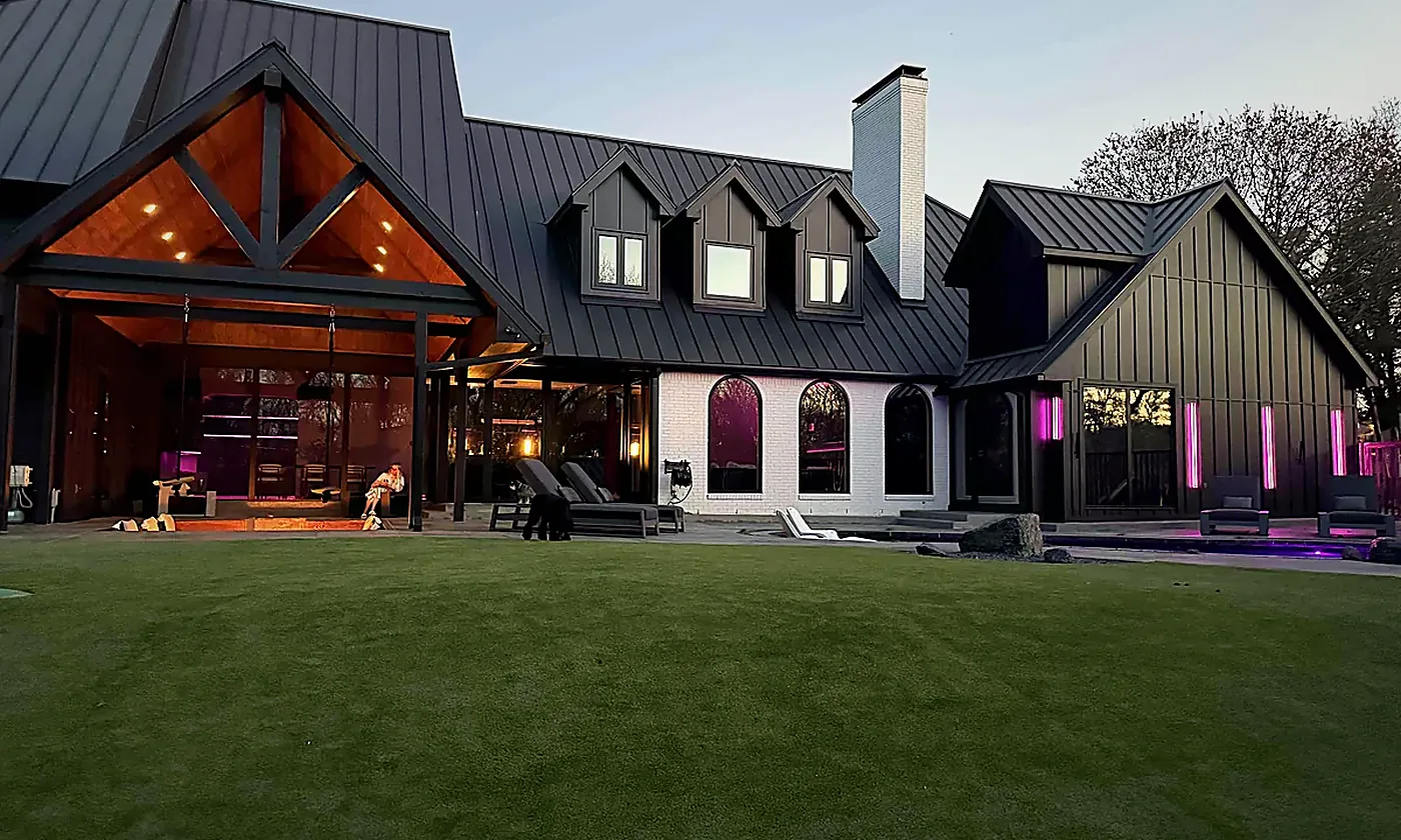 Texas home at dusk with its interior and landscape lighting on, a WH Technologies installation