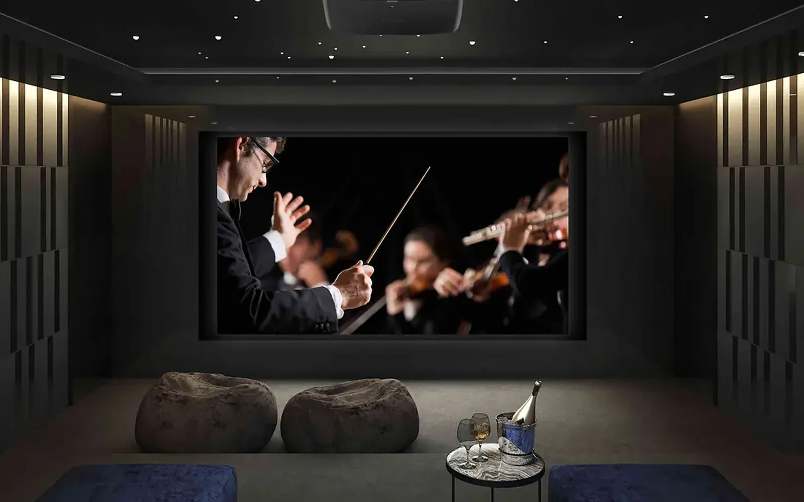 Home theater with an orchestra on the screen, wall sconces and dark walls