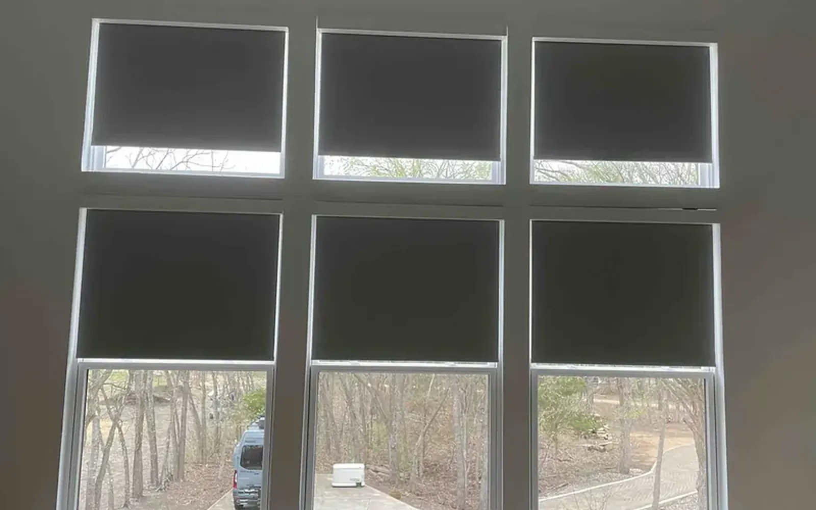 Grid of tall windows with motorized shades lowered to the same height