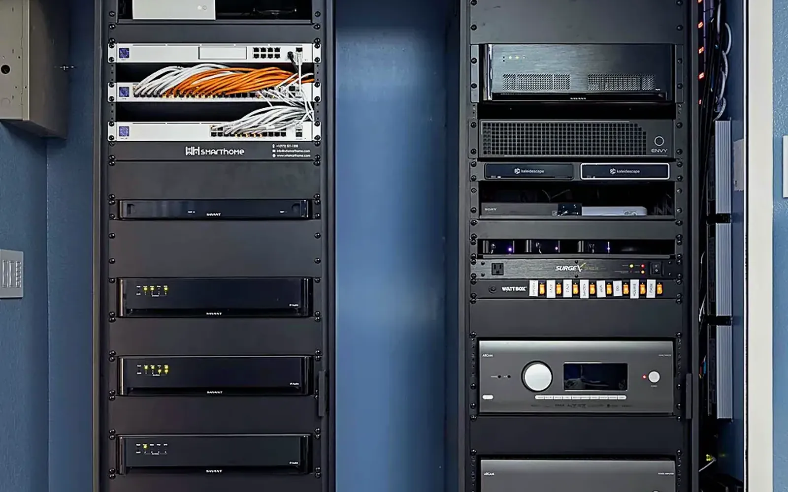 Equipment rack during trim-out with AV components mounted and cabled inside a dark cabinet