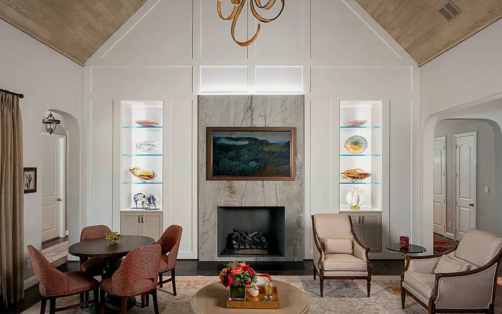 Living room from the NARI award-winning whole-home tunable lighting project, with a vaulted ceiling and warm light on the stone fireplace and shelves