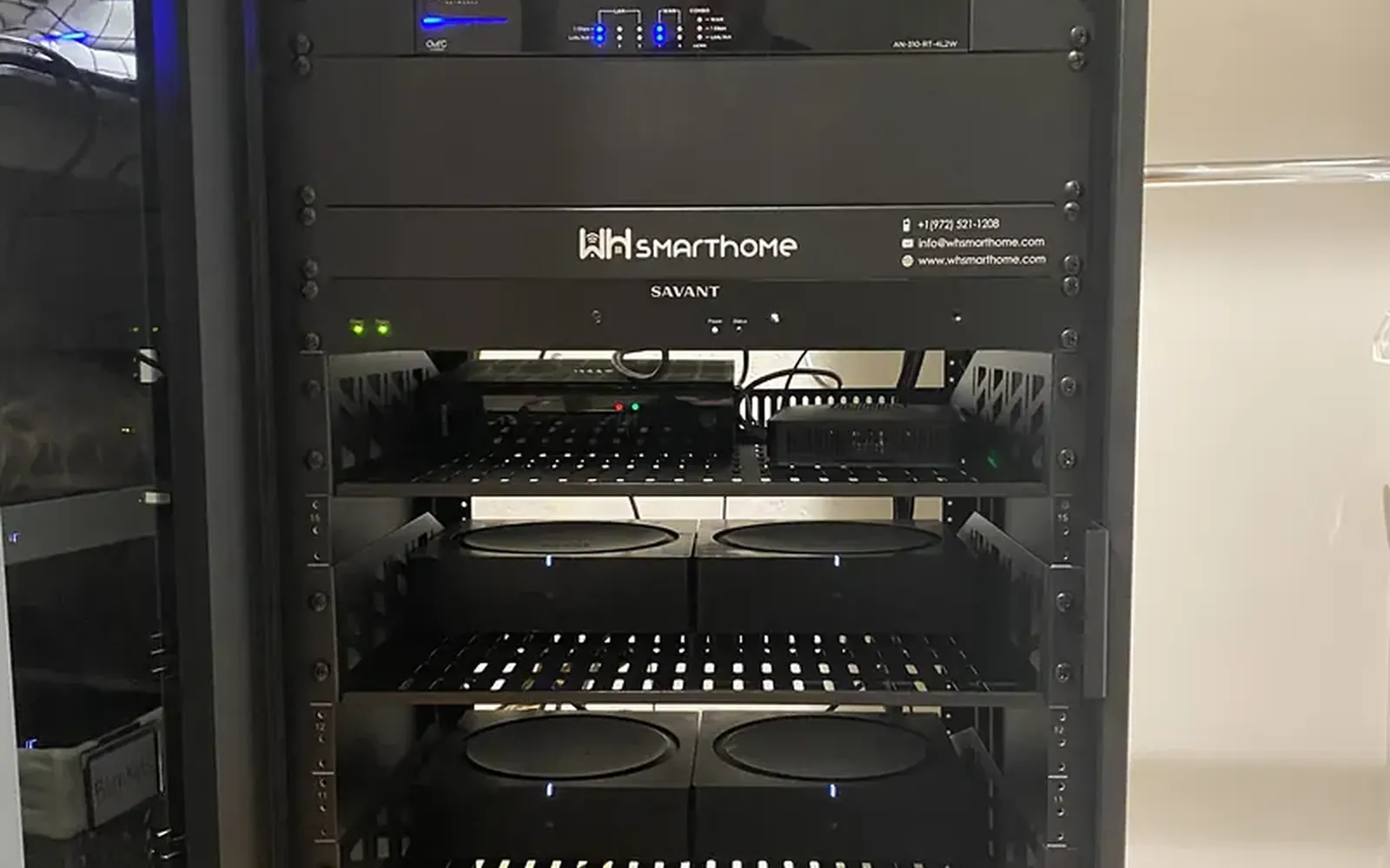 Equipment rack in a dark closet with network switches, amplifiers and control processors stacked and neatly cabled