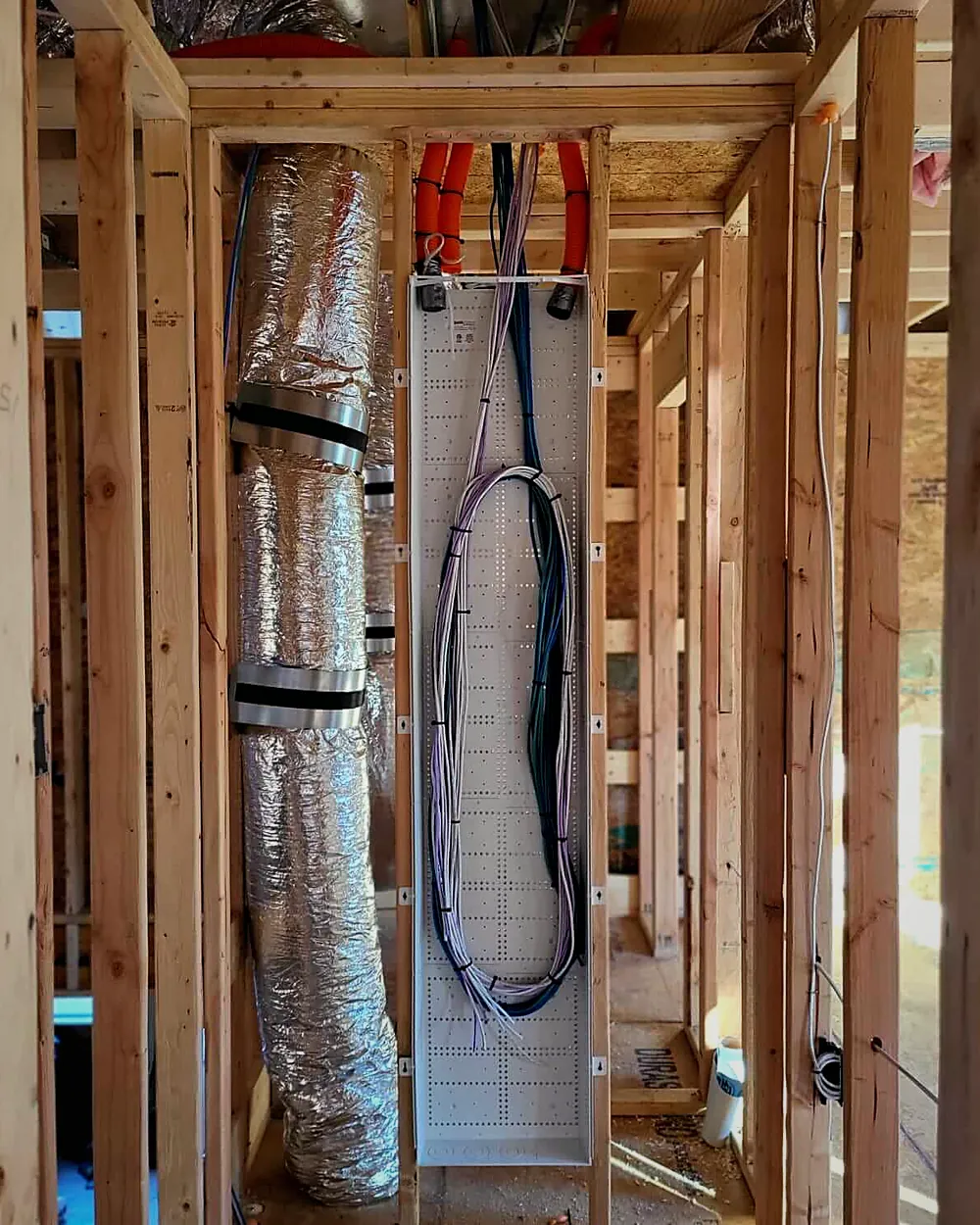 Low-voltage cable and conduit run through the framing of a custom home before drywall
