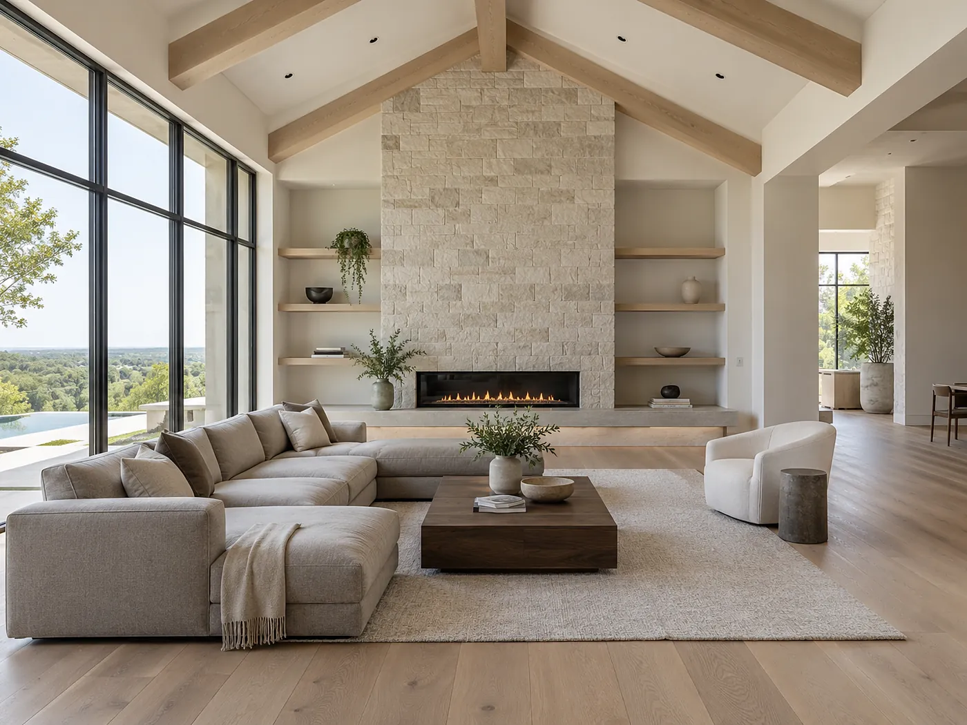 Open-plan living room with a vaulted beamed ceiling, stone fireplace wall and floor-to-ceiling windows in bright afternoon daylight, the architectural lighting switched off