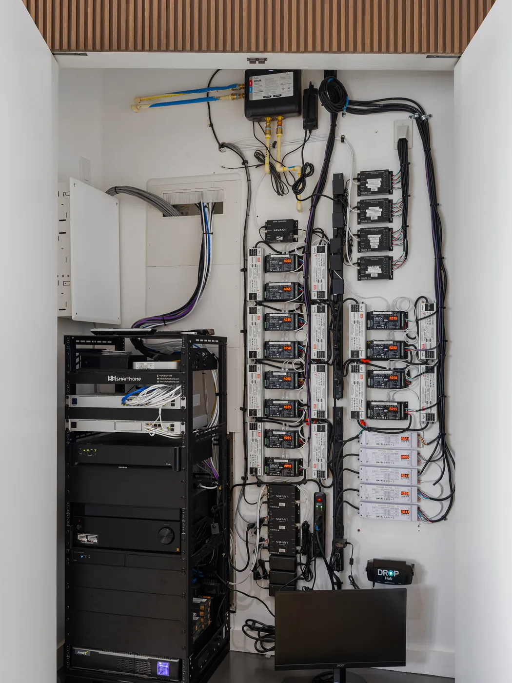 Equipment rack hidden inside a walnut closet, cables dressed and labeled