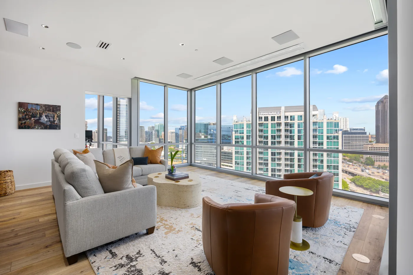 Living room by day with two sofas, a blue display niche and the skyline through the glass