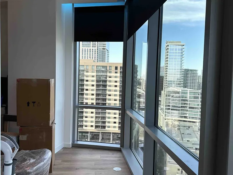 High-rise apartment window with motorized shades and the Dallas skyline outside