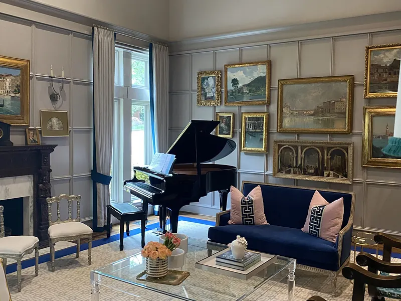 Music room with a grand piano, gallery wall and a navy sofa