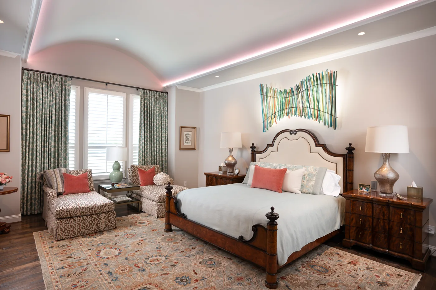 The same bedroom with the cove light set to a warm pink and a ring light over the bed