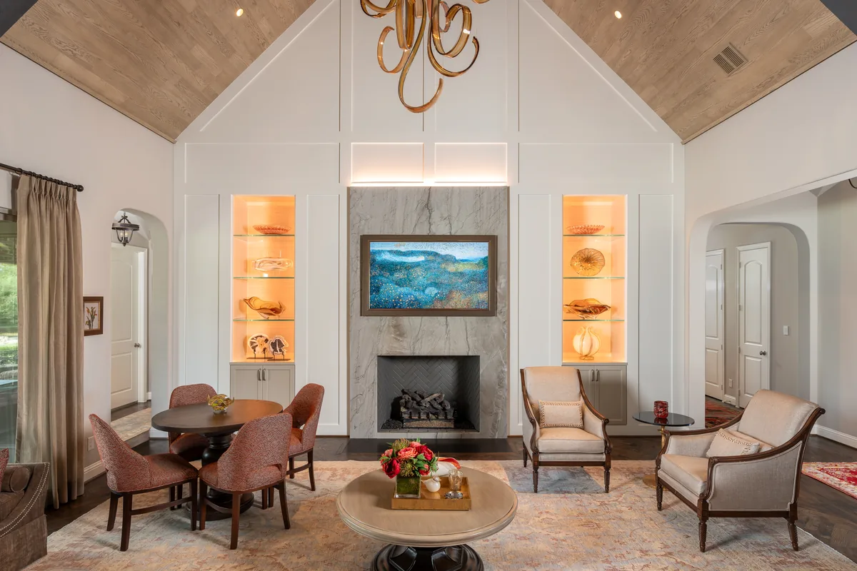 Living room after: marble fireplace, lit display niches and layered ceiling light