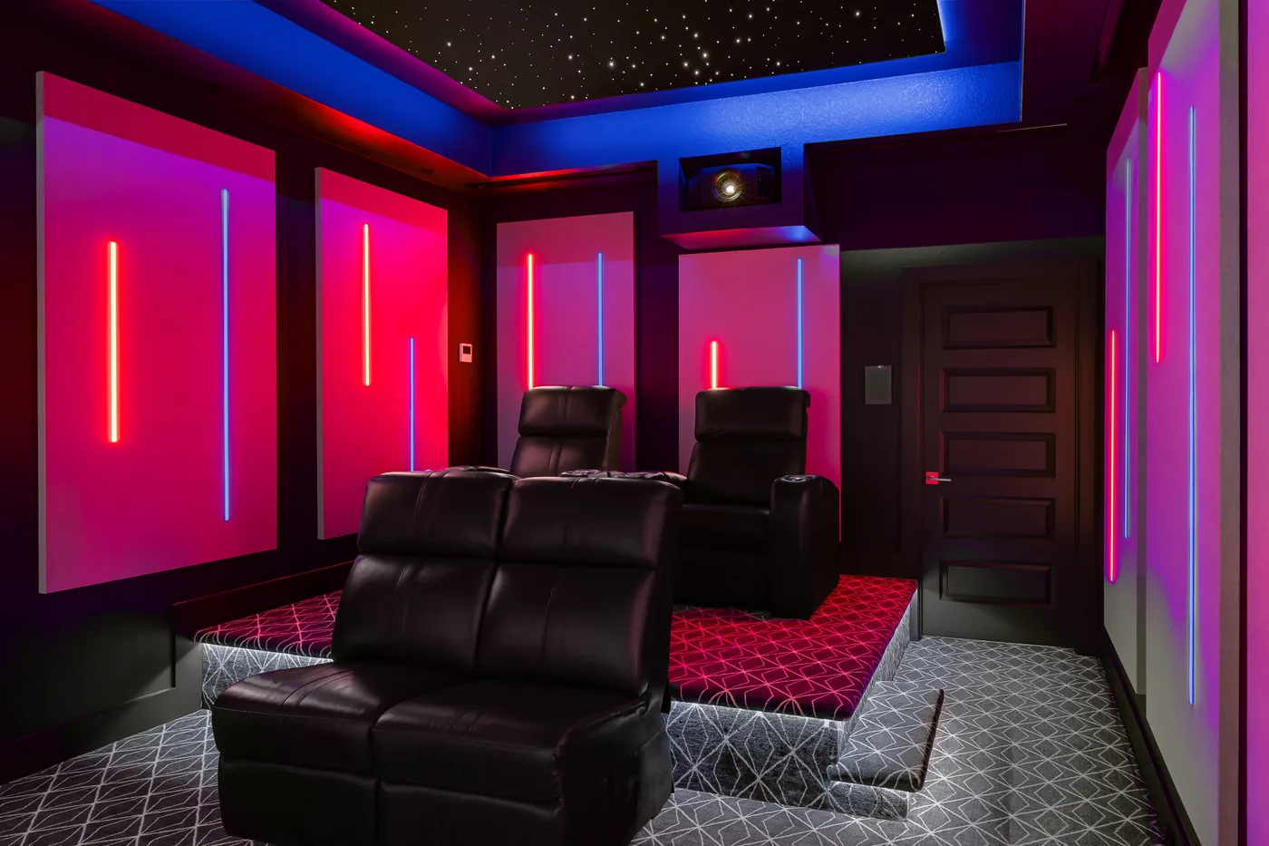 The theater in a magenta lighting scene, star ceiling on, recliners facing the screen