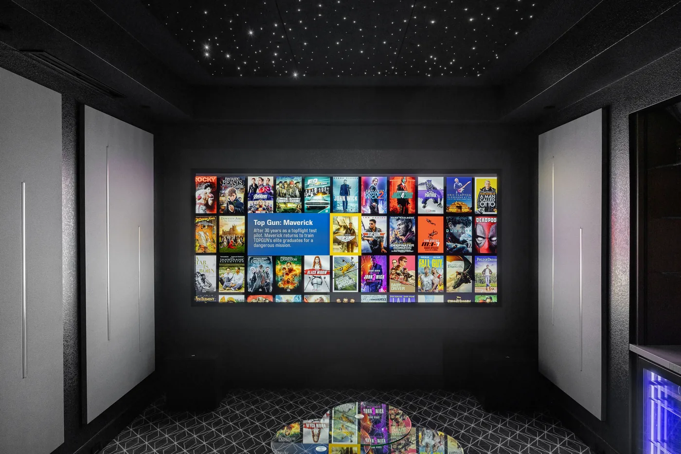 Straight-on view of the screen showing the movie library between lit acoustic panels
