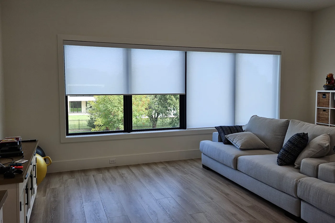 Family room with large windows and motorized roller shades half lowered