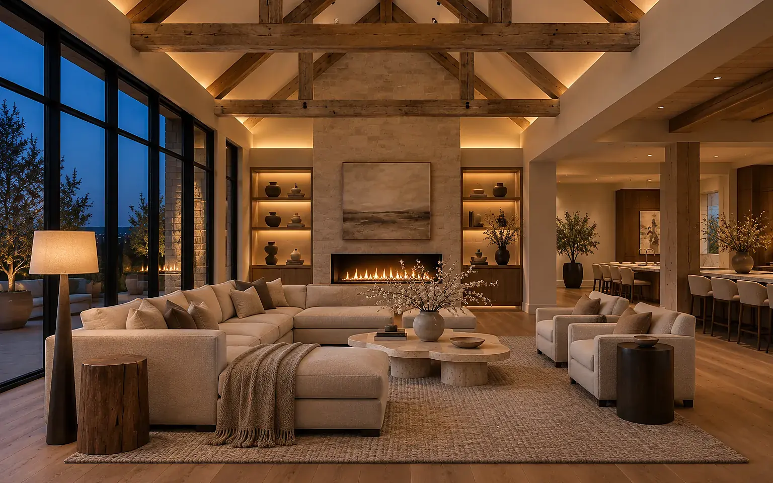 Open-plan living room at dusk in a warm evening lighting scene: cove light under the beams, lit shelves, a floor lamp and dimmed downlights
