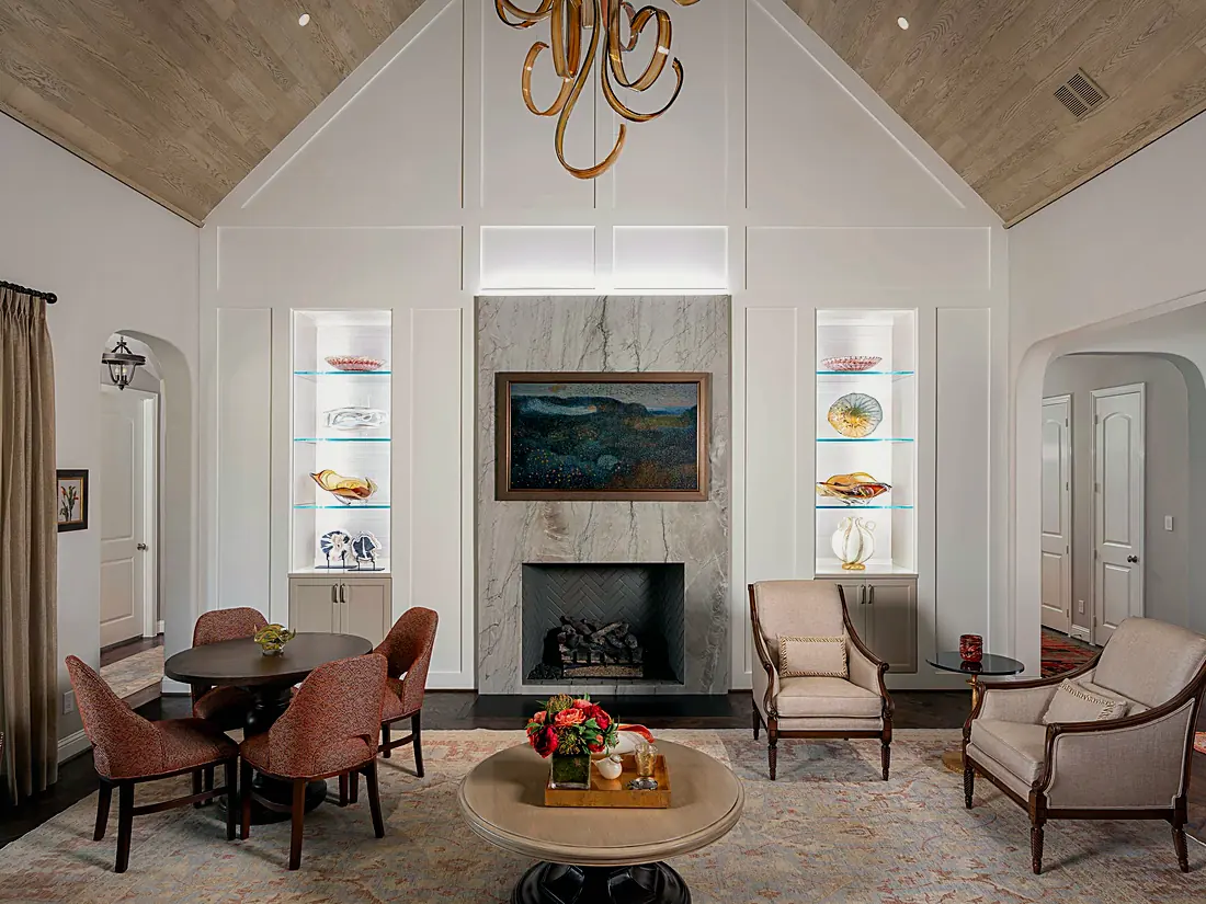 Living room of the NARI Remodeler of the Year 2025 project: lit display niches, cove light along the vaulted ceiling and a chandelier over the seating