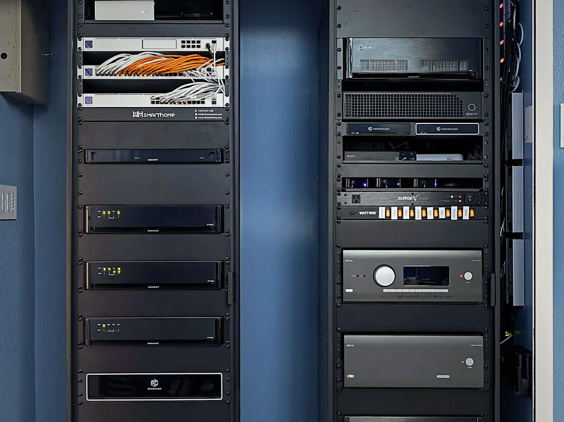 Ventilated equipment rack with network switches, patch panel, amplifiers and a labelled WH Technologies panel in a closet